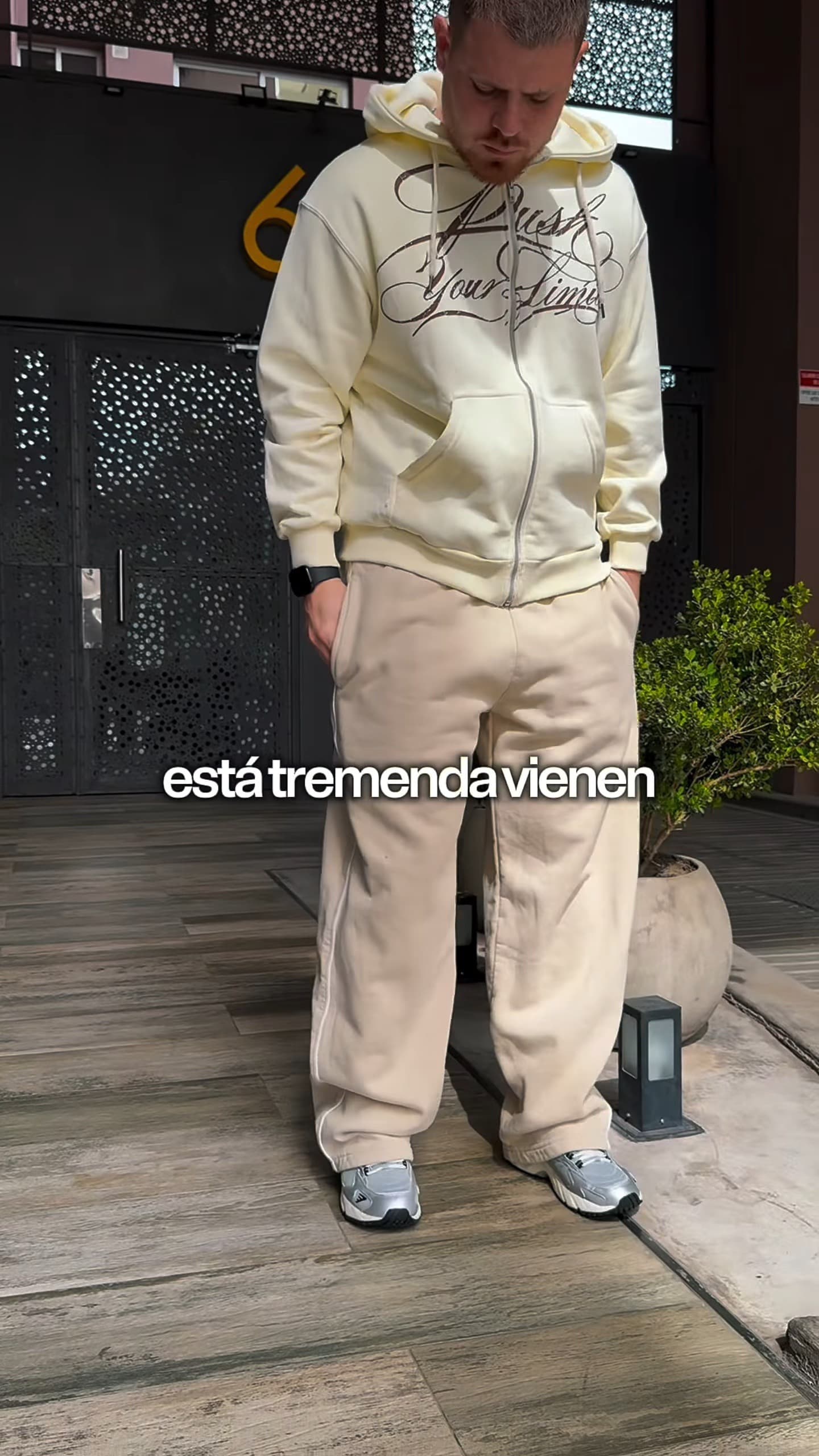 Look 1 del reel de Lennon: buzo canguro oversize y babucha en total crema con zapatillas claras